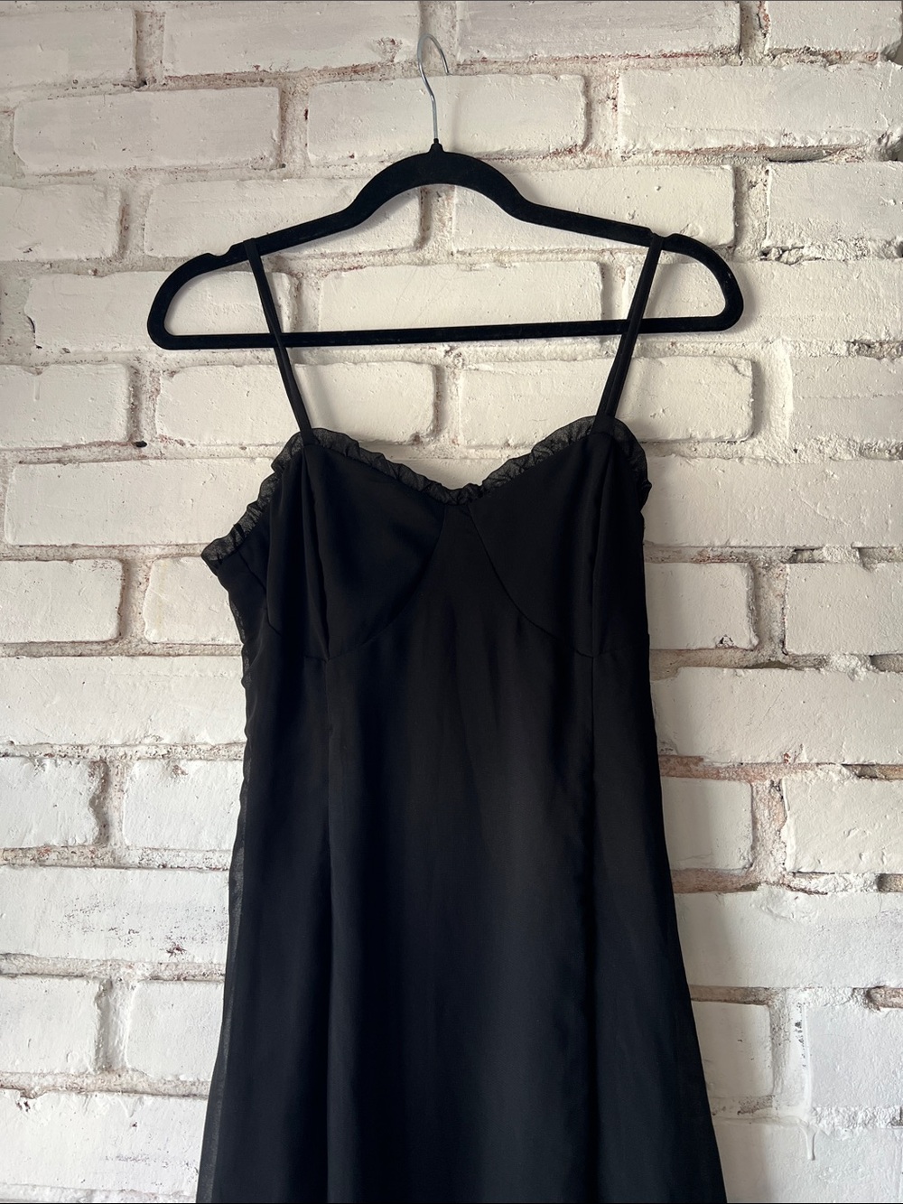 Fitted black spaghetti strap dress and corset and ruffle detail and tiered skirt